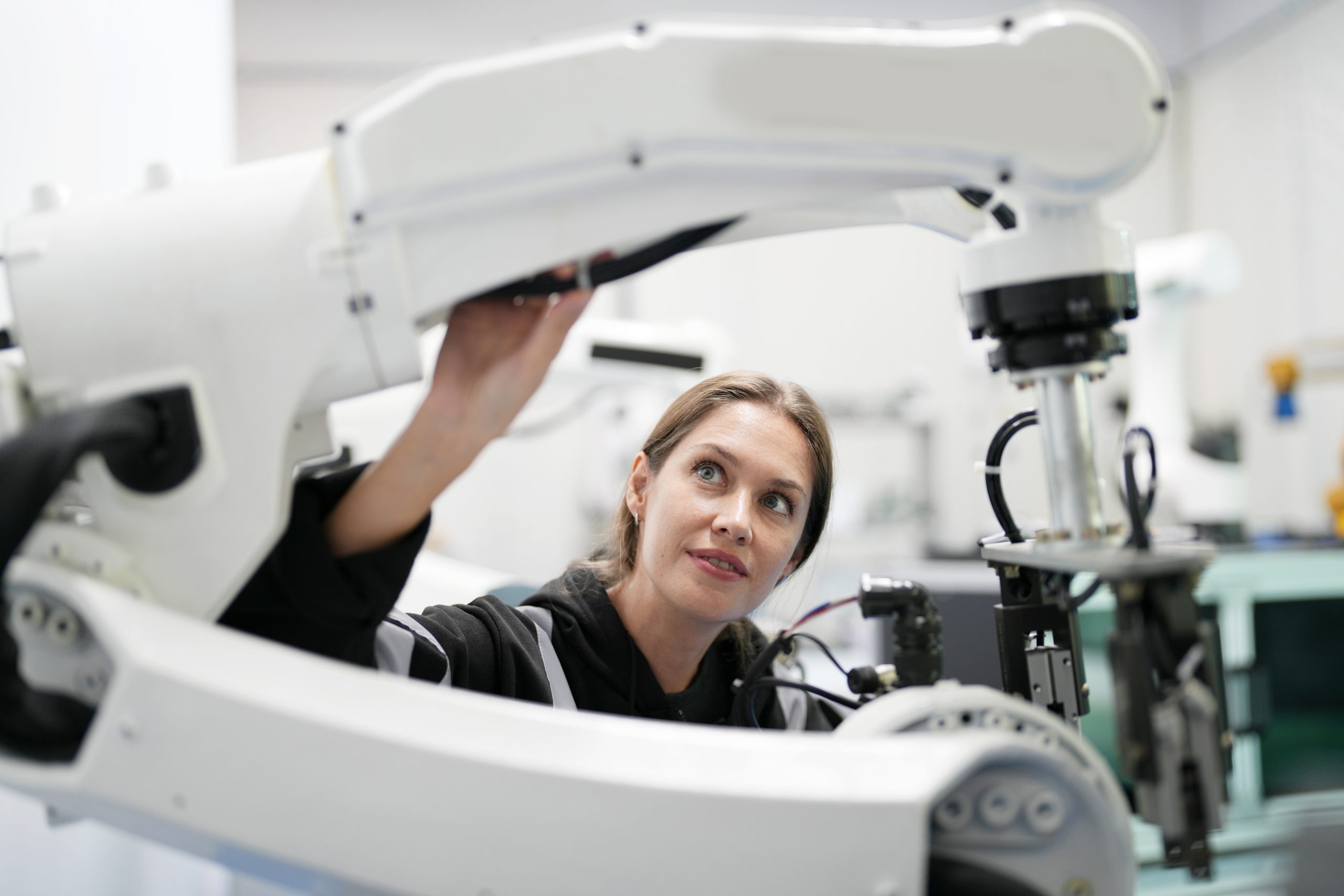 Robotic Arm engineer check on equipment in its with software of an Artificial Intelligence Computer Processor Unit. High Tech Robotic Arm with an Artificial Intelligence Computer Processor Unit in its.