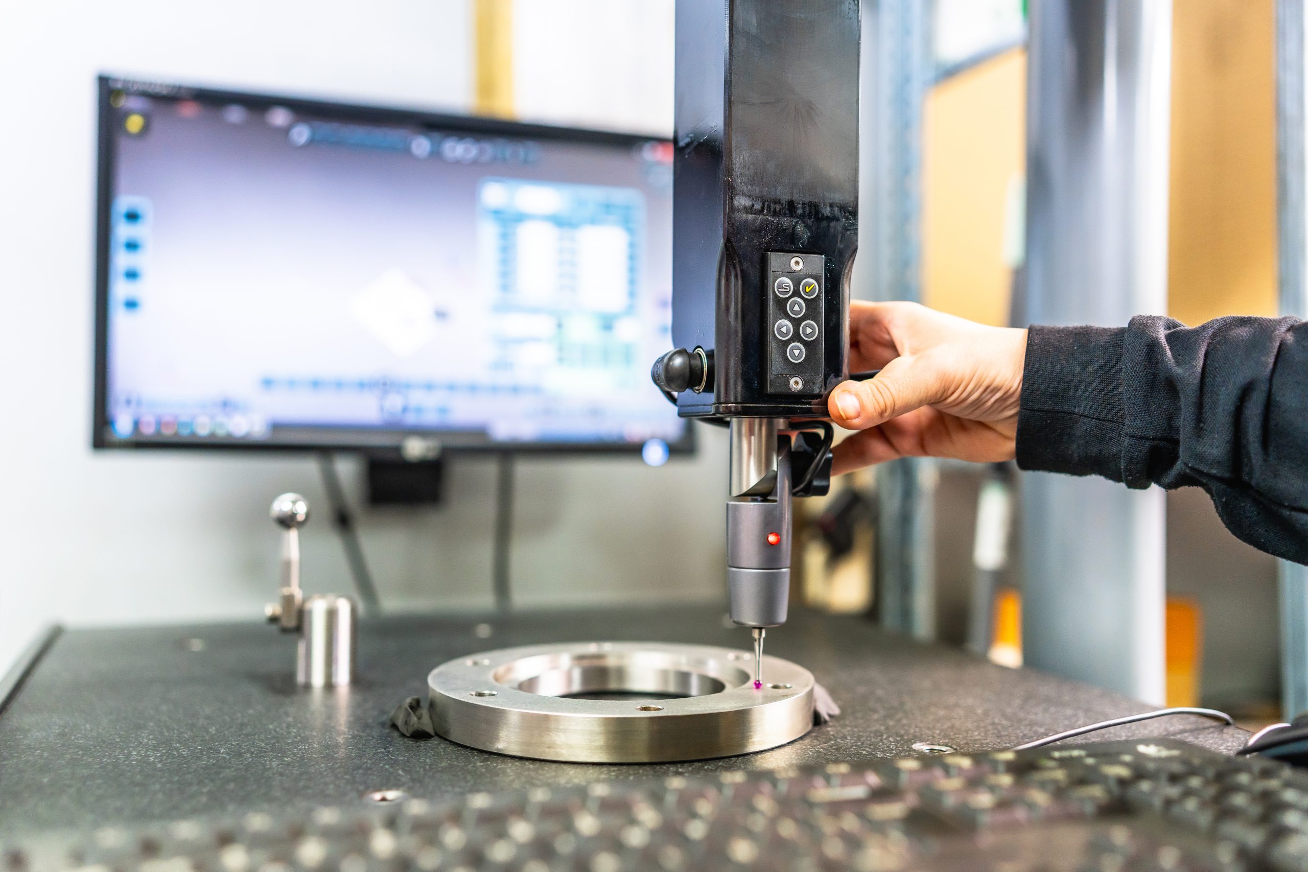Close-up of the hand of a technician working with three-dimensional verification and measuring machine in a cnc innovative metal factory